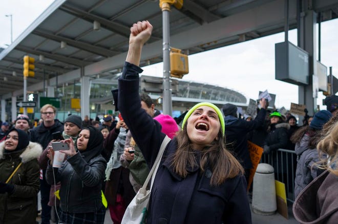 A protester raises her fist and shouts as she joins others assembled at John F. Kennedy International Airport in New York on Saturday after two Iraqi refugees were detained while trying to enter the country. On Friday, Jan. 27, President Donald Trump signed an executive order suspending all immigration from countries with terrorism concerns for 90 days. Countries included in the ban are Iraq, Syria, Iran, Sudan, Libya, Somalia and Yemen, which are all Muslim-majority nations.