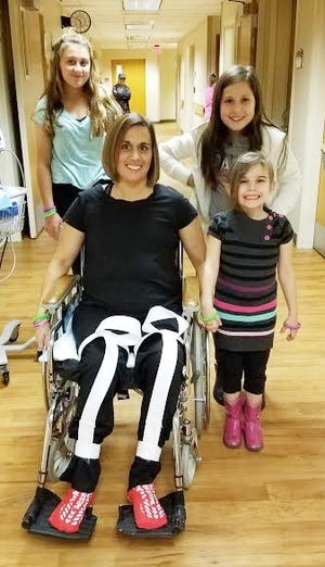 Stacy Peacock, center, with her daughters, Sesleigh, Zoey and Jory visit while recovering in the hospital. Photo submitted