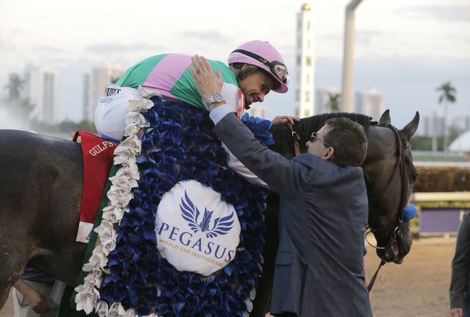 Jockey Mike Smith is congratulated by assistant trainer Jim Barnes after riding Arrogate to victory Saturday in the inaugural running of the $12 million Pegasus World Cup horse race at Gulfstream Park in Hallandale Beach. LYNNE SLADKY/AP PHOTO