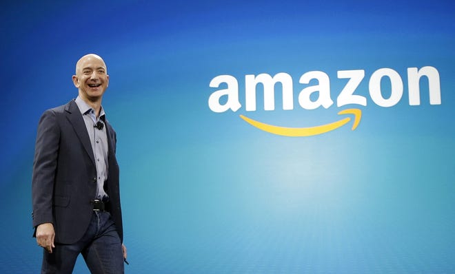 FILE - In this June 16, 2014 file photo, Amazon CEO Jeff Bezos walks on stage for the launch of the new Amazon Fire Phone, in Seattle. Amazon.com reports quarterly financial results on Thursday, Oct. 23, 2014. (AP Photo/Ted S. Warren, File) ORG XMIT: NYBZ197