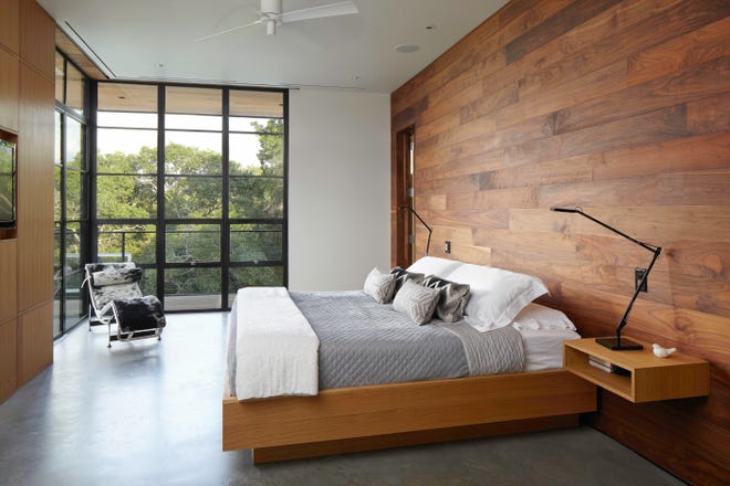 Walnut planks clad a feature wall in the master bedroom. (Brandpoint)