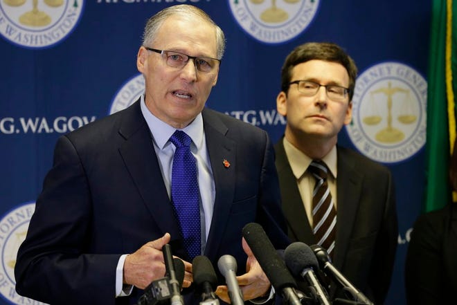 Washington Gov. Jay Inslee, left. talks to reporters as Washington Attorney General Bob Ferguson, right, looks on, Monday in Seattle. Ferguson announced that he is suing President Donald Trump over an executive order that suspended immigration from seven countries with majority-Muslim populations and sparked nationwide protests.