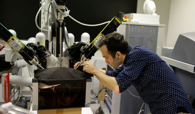 Iranian-born bioengineer researcher Nima Enayati works on a robotic surgery machine during an interview with the Associated Press at the Polytechnic University of Milan, Italy, Tuesday, Jan. 31, 2017. An Iranian researcher at Milan’s Polytechnic University, Enayati was refused check-in Monday at Milan’s Malpensa Airport for his U.S.-bound flight on Turkish Airlines after the Trump administration’s executive order came down. (AP Photo/Luca Bruno)