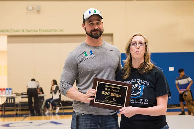 HONORED - Uwharrie Charter Academy wrestling coach Chris Waddell is given a plaque from Uwharrie Charter Academy Superintendent Heather Soja after Waddell earned his 500th coaching victory Tuesday night.