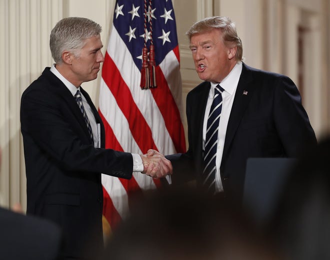 Judge Neil Gorsuch shakes hands with President Donald Trump as he is announced as Trump's choice for Supreme Court Justice during a televised address from the East Room of the White House in Washington, Tuesday, Jan. 31, 2017 THE ASSOCIATED PRESS
