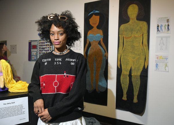 Ajani Russell poses with her artwork, 'Female Figures,' at the Animated Women symposium at California Institute of the Arts in Valencia, Calif.