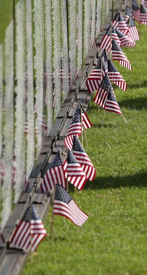 (File) Flags line the base of the wall at The Vietnam Traveling Memorial Wall, on display at the soccer fields on Rolling Acres Road in Lady Lake, Florida, on Tuesday, Nov. 10, 2015.