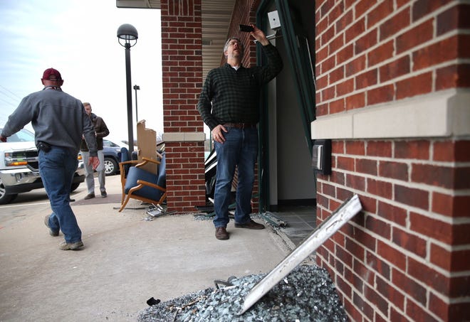 Structural engineer Patrick Earney, center, evaluates damage to the Columbia Podiatry office at 305 N. Keene St. on Wednesday after a small SUV crashed through the front door.