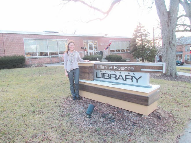Brittny Paci, president of the Lilian S. Besore Memorial Library Association in Greencastle, is shown with a new sign donated by Friends of the Library. For video of Paci talking about the library's Spring Fling, visit www.echo-pilot.com.