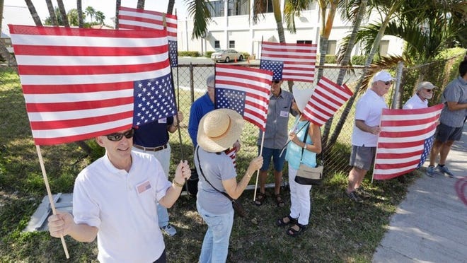 About two dozen people gathered on Southern Boulevard in West Palm Beach, less than a mile from President Trump’s Mar-a-Lago Club, to protest his inauguration on Jan. 20.