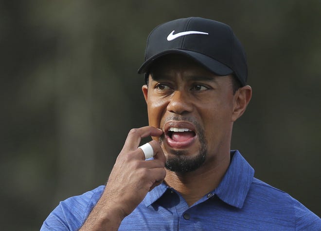 Tiger Woods reacts on the 11th hole during the first round of the Dubai Desert Classic golf tournament on Thursday in Dubai, United Arab Emirates. Woods withdrew from the tournament with back spasms after shooting an opening-round 5-over 77. (AP Photo/Kamran Jebreili)