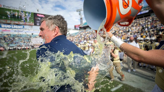 Georgia Tech head coach Paul Johnson is doused by Gatorade after the Yellow Jackets won the TaxSlayer Bowl against Kentucky on Dec. 31 in Jacksonville, Fla. Tasxlayer Bowl officials say the area was awash in increased spending this year from fans supporting both teams. (Associated Press)