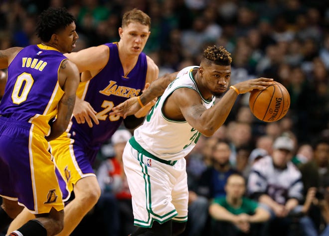 Boston's Marcus Smart eludes Lakers' players during Friday night's game.