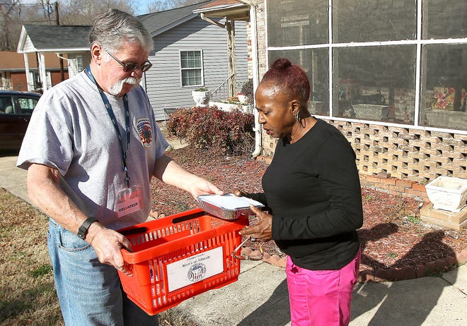 Meals on Wheels volunteer Joe Petrellese delivers a lunch for Mary Tate to her caregiver Patrica Wilson. The program serves 223 people, but due to a lack of volunteers and insufficient funding, it cannot accommodate 258 more people on a waiting list. [JOHN CLARK/THE GAZETTE]