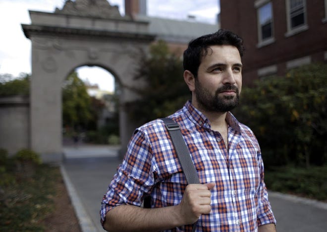 In this photo, Khaled Almilaji stands for a portrait on the campus of Brown University where he is studying for a master's degree in public health. Almilaji, said he is stuck in Turkey because President Donald Trump's executive order does not permit him to return to Providence where he lives with his his pregnant wife.