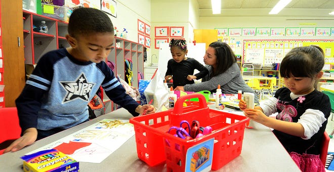 Preschoolers (from left) Jeremiah Phillips, 4; Egypt Brown, 4;  and Sophia Tillingham, 4, get help from teacher Nicole Peoples in the Art and Fine Motor Learning Center at the John Brainerd Elementary School in Mount Holly on Tuesday, Dec. 18, 2016.