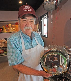 Owner Art Cabral shows off a Patriots cake at Art's International Bakery.