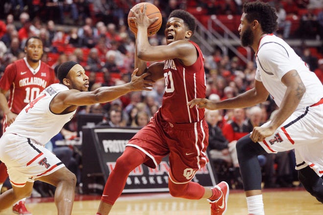 Oklahoma guard Kameron McGusty drives to the basket between Texas Tech guard Shadell Millinghaus and forward Aaron Ross during the second half of an NCAA college basketball game Saturday, Feb. 4, 2017, in Lubbock, Texas. [AP PHOTO]