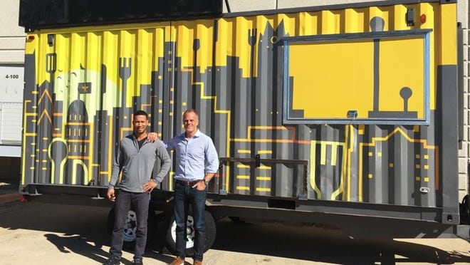 Snap Kitchen head of digital Jon Carter (left) and chief executive officer David Kirchhoff (right) stand in front of a "pod" trailer that will offer meals from the company in downtown Austin later this month. The company is pushing hard in its digital efforts to offer more delivery options and to help customers fulfill their dietary needs with curated meals plans.