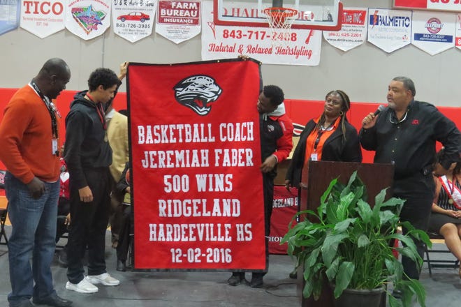 Jasper County School District/ Special to JCST Ridgeland-Hardeeville High boys basketball coach Jeremiah Faber was presented with a banner for winning his 500th career game. He was also presented with a basketball trophy signed by the team. The awards were given on behalf of RHHS, the athletic department, superintendent Donald Andrews and the board of education. Faber was also selected at the district’s “Unsung Leader” during the superintendent’s administrators meeting. The honor is awarded to employees who exhibit extraordinary leadership skills.