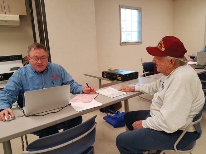 AARP Foundation Tax-Aide volunteer Billy Piner, left, prepares income tax returns for Joseph Kogut, 92, of Cape Carteret. Photo by Jannette Pippin/Daily News staff.