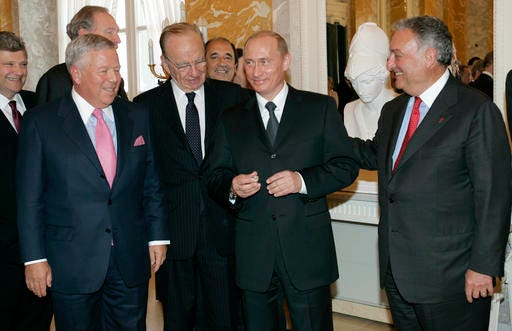 FILE - In this June 25, 2005, file photo, Russian President Vladimir Putin, second right, holds the diamond-encrusted 2005 Super Bowl ring belonging to New England Patriots owner Robert Kraft, left , as News Corp. Chairman Rupert Murdoch, second left, and Citigroup Chairman Sanford Weill look on during a meeting of American business executives at the 18th century Konstantin Palace outside St. Petersburg, Russia. Kraft won his fifth Super Bowl ring on Feb. 5, 2017, but his third ring remains with Putin. (AP Photo/Alexander Zemlianichenko, File)