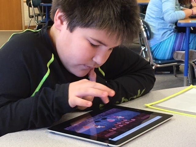 A Springmore Elementary student works on an iPad as his teacher uses an Apple TV during lessons. The technology was purchased through a Facebook grant. Special to The Star