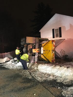 A crew from DirenzoTowing & Recovery works to right a sander truck that overturned Tuesday night in the yard of 36 Hillcrest Ave., Worcester. [Submitted Photo/DirenzoTowning & Recovery]