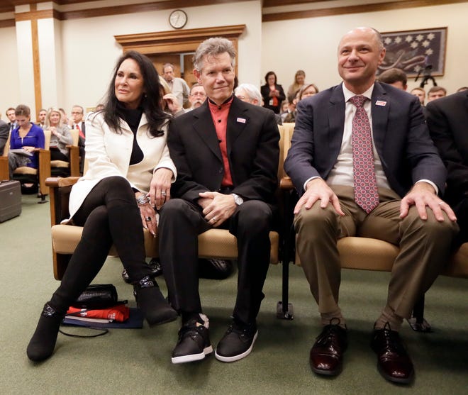 Country singer Randy Travis, center, sits with his wife, Mary, left, and Dr. Blaise Baxter, right, of Erlanger Hospital in Chattanooga, Tenn., before a meeting of the Senate Health and Welfare Committee on Wednesday, Feb. 8, 2017, in Nashville, Tenn. Randy Travis, who suffered a stroke in 2013, attended the hearing for Stroke Awareness Day at the legislature. Dozens of country stars, from Garth Brooks to Kenny Rogers, are scheduled to perform at a tribute show Wednesday night in Nashville to honor Travis. (AP Photo/Mark Humphrey)