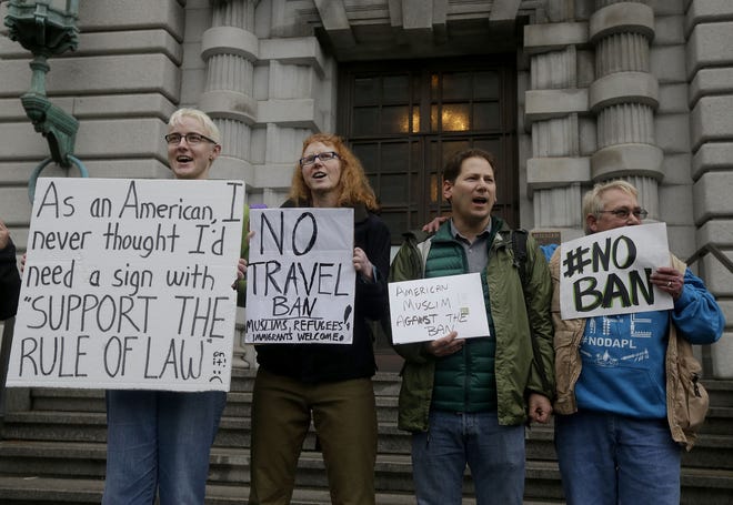 Protesters (from left) Kay Aull, Beth Kohn, Paul Paz y Mino and Karen Shore stand outside of the 9th U.S. Circuit Court of Appeals in San Francisco on Tuesday, Feb. 7, 2017. President Donald Trump's travel ban faced its biggest legal test yet Tuesday as a panel of federal judges heard arguments from the administration and its opponents about two fundamentally divergent views of the executive branch and the court system.