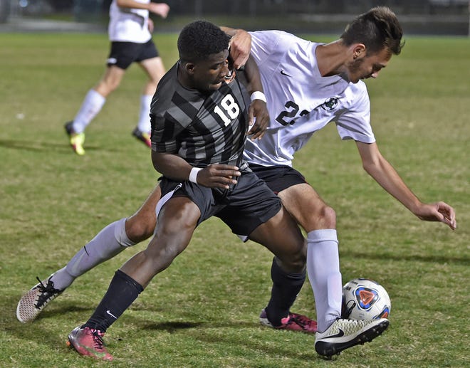 Lakewood Ranch High's Anthony Hroncich (22) battles Sanford Seminole's Mathias Etoh (18) for control of the ball during the Class 5A state semifinal on Friday night at Lakewood Ranch High School. [HERALD-TRIBUNE STAFF PHOTO / THOMAS BENDER]