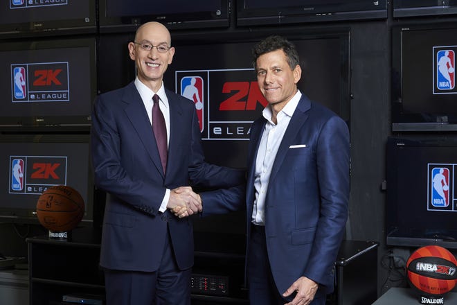 NBA Commissioner Adam Silver, left, and Take-Two CEO Strauss Zelnick pose for a photo Wednesday at the NBA headquarters in New York. Video gamers now have a chance to compete for an NBA title, in an actual NBA arena and get paid by the some of the same people who pay LeBron James and Steph Curry. The "NBA 2K eLeague" is coming, the first eSports league operated by one of the four major pro sports leagues in the United States. [Jenn Pottheiser/NBA via AP]