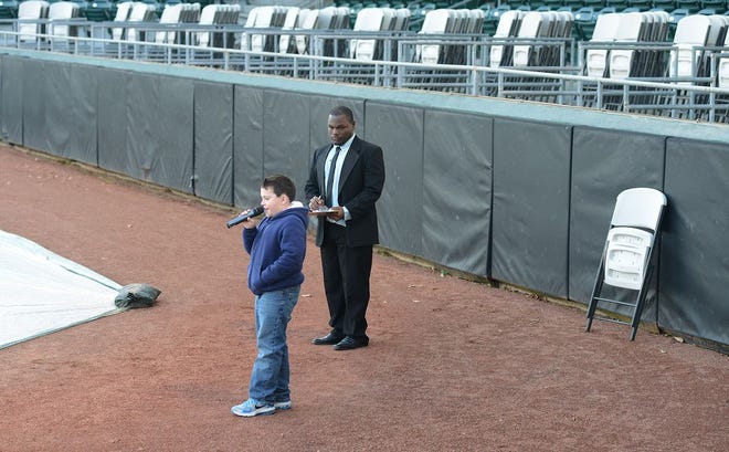 Kolby Smith, 11, sings the national anthem as Donta Lewis, Wood Ducks coordinator of operations, looks on Friday inside Grainger Stadium. Photo by Janet S. Carter / The Free Press