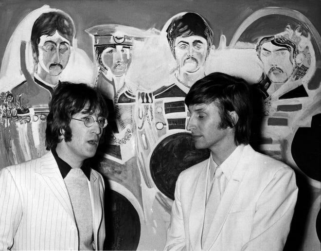 John Lennon and artist Jonathan Hague (right) talk in 1967 in front of 'The Sargent Pepper' painting in London, [File Photo/The Associated Press]