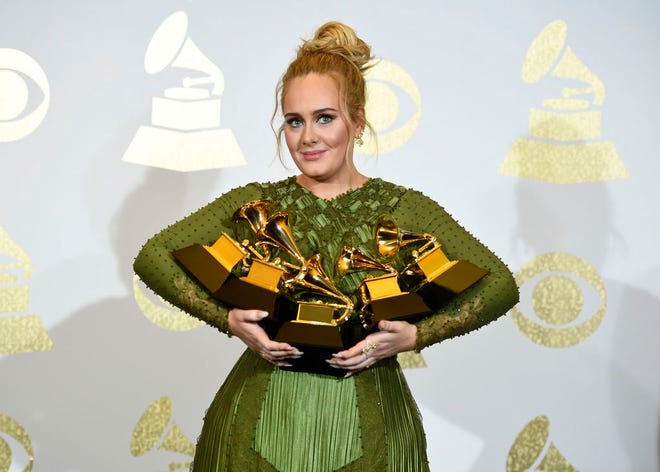 Adele poses in the press room with the awards for album of the year for "25", song of the year for "Hello", record of the year for "Hello", best pop solo performance for "Hello", and best pop vocal album for "25" at the 59th annual Grammy Awards at the Staples Center on Sunday, in Los Angeles. (Photo by Chris Pizzello/Invision/AP)