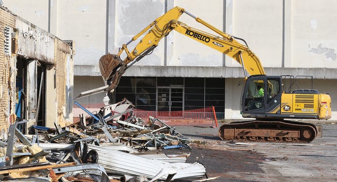 An excavator begins the process early Tuesday morning of tearing down the automotive service center on the former Sears property on West Franklin Boulevard. The demolition is being carried out as part of Gastonia's creation of the FUSE district. [MIKE HENSDILL/THE GAZETTE]