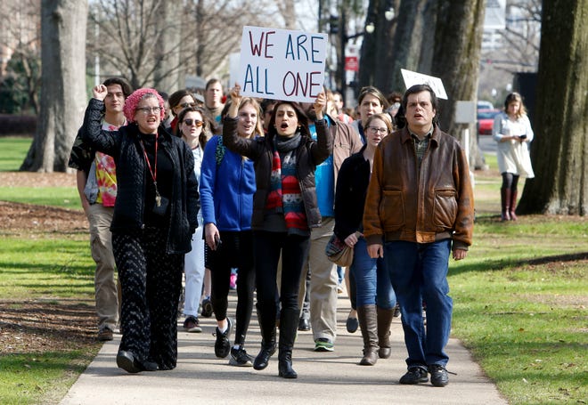 Demonstrators chant and wave signs as they march beside University Blvd. at the University of Alabama in Tuscaloosa, Ala., to support an open campus and oppose the travel ban imposed by President Donald Trump Thursday, Feb. 9, 2017. Immigrants in cities across the country are expected to stay home Thursday to show their importance to the U.S. economy. GARY COSBY JR./THE TUSCALOOSA NEWS