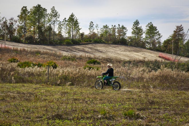 Kathy Sokol Lane, 48, rides her dirt bike alongside the Sabal Trail Transmission pipeline path at her property in Dunnellon on Dec. 30. Riding dirt bikes has been her passion for the past 10 years, but now, Lane thinks that her hobby is in jeopardy due to the 515-mile natural gas pipeline that runs in front of and beside her property. "I just think it's bad all around- for the environment, for people's safety, for the drinking water," Lane said. "It's just a no-win situation." [Andrea Cornejo/Staff photographer]
