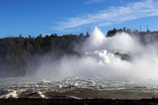 Water gushes from the Oroville Dam's main spillway Tuesday, Feb. 14, 2017, in Oroville, Calif. Crews working around the clock atop the crippled Oroville Dam have made progress repairing the damaged spillway, state officials said Tuesday. (AP Photo/Marcio Jose Sanchez)