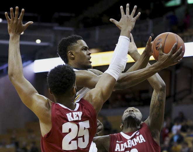Missouri guard K.J. Walton, center, goes for a layup past Alabama forwards Braxton Key (25) and Jimmie Taylor, right, during the first half of an NCAA college basketball game in Columbia, Mo., Wednesday. Alabama won, 57-54. (Timothy Tai/Columbia Daily Tribune via AP)