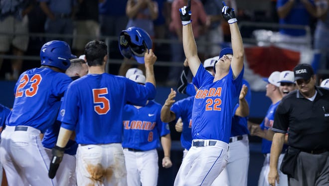 Florida designated hitter JJ Schwarz (22) celebrates a grand slam home run against Florida State in a super-regional game last year. Schwarz is among 11 returning position players for the Gators this season (AP Photo/Ronald Irby).