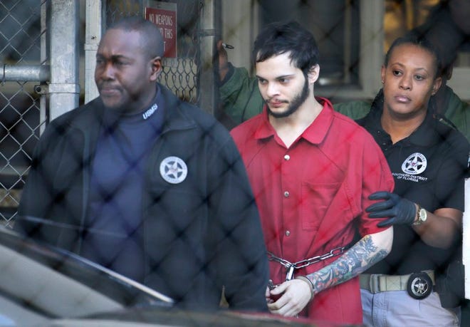 In this Jan. 30 file photo, Esteban Santiago, center, is led from the Broward County jail for an arraignment in federal court in Fort Lauderdale. Lawyers for Santiago, 26, who is accused of killing five people and wounding six in a Florida airport shooting rampage, told a judge Thursday he is competent to proceed with his court case despite indications of mental illness.