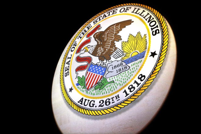 Stage crew workers adjust the lighting on the Illinois state seal at the Prairie Capital Convention Center Saturday, Jan. 10, 2015, in Springfield. (AP Photo/Seth Perlman)