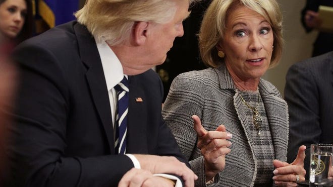 U.S. Secretary of Education Betsy DeVos speaks as President Donald Trump listens during an event at the White House on Tuesday in Washington, D.C.