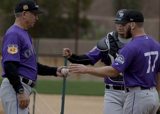 Colorado Rockies manager Bud Black, left, works with Colorado Rockies relief pitcher Sam Moll and catcher Chris Rabago during spring baseball practice in Scottsdale, Ariz., on Friday. [AP Photo/Chris Carlson]