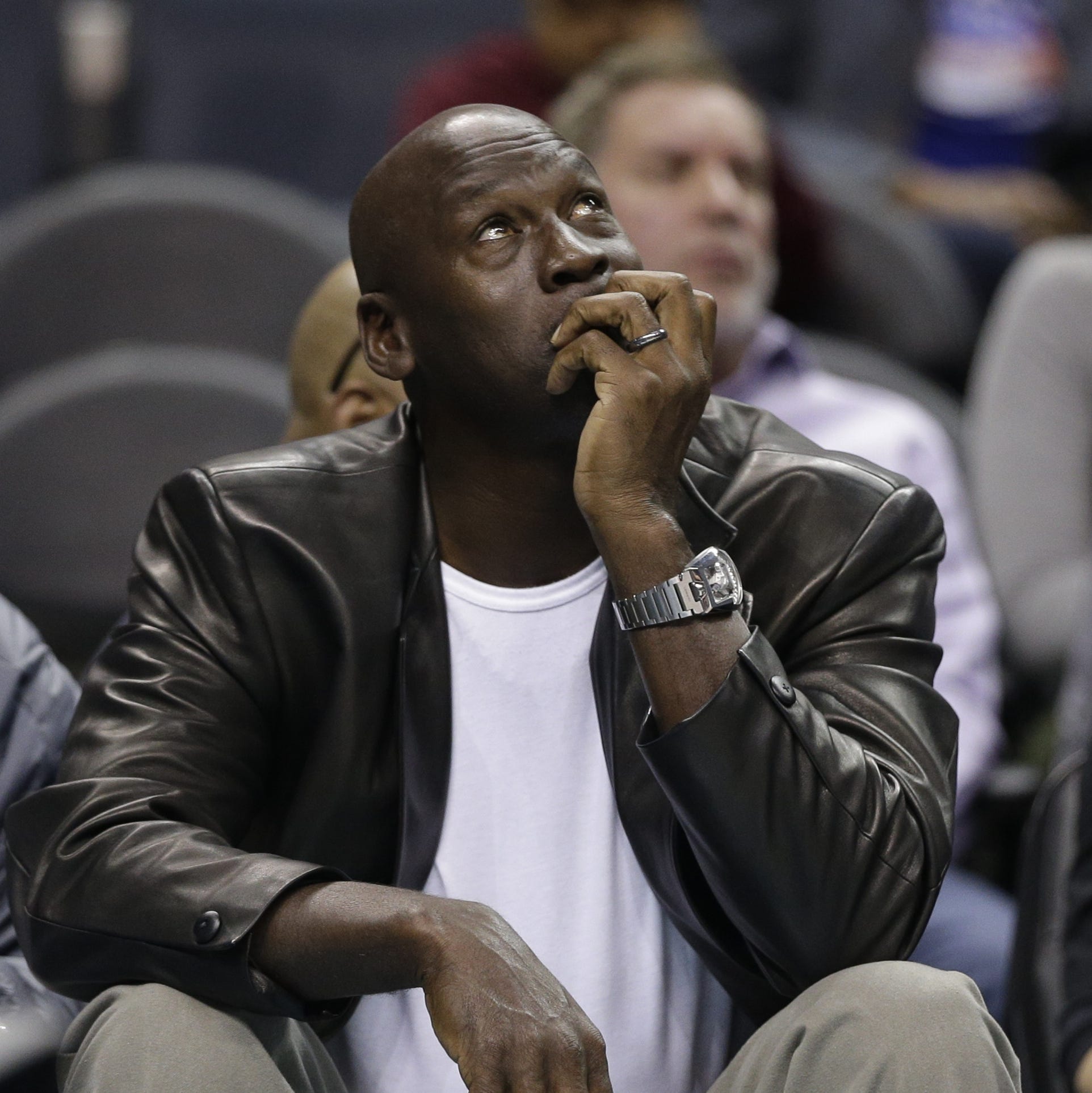 Charlotte Hornets owner Michael Jordan looks at a scoreboard in the first half of an NBA basketball game against the Portland Trail Blazers in Charlotte, N.C., Wednesday, Jan. 18, 2017. (AP Photo/Chuck Burton)