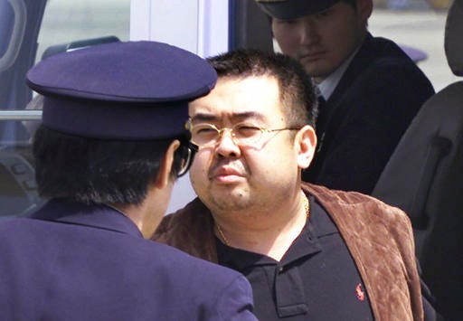 FILE - This May 4, 2001, file photo shows Kim Jong Nam, exiled half brother of North Korea's leader Kim Jong Un, escorted by Japanese police officers at the airport in Narita, Japan. Kim Jong Nam, 46, was targeted Monday, Feb. 13, 2017, in the Kuala Lumpur International Airport, Malaysia, and later died on the way to the hospital, according to a Malaysian government official. (AP Photo/Itsuo Inouye, File)