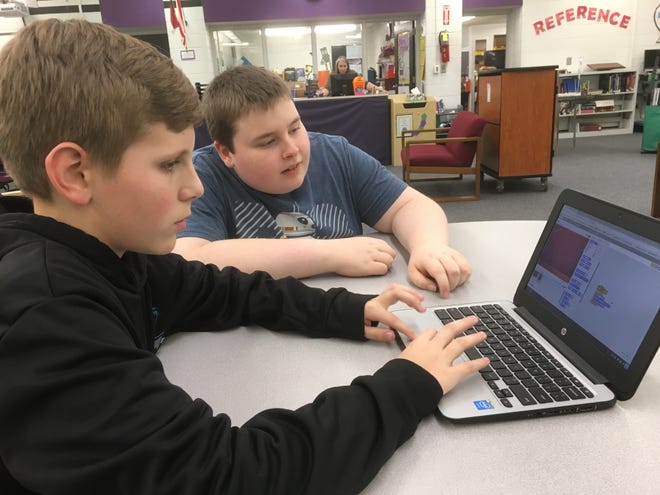 Pictured from left to right, W.C. Friday Middle School students Walker Hayes, 11, and Wesley Greeter, 14, work with computer coding software in the school library Thursday afternoon. They have been learning about coding since October with the school's new computer science club. [ERIC WILDSTEIN/THE GAZETTE]