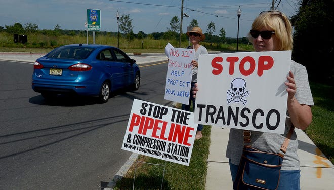 People Over Pipeline members Rita Romeu and Carole Cann stand along the roundabout at Old York Road and Route 528 in Chesterfield and hold signs in protest of the proposed pipeline and compressor station that will run along Route 528 in Chesterfield, on Tuesday, July 26, 2016.