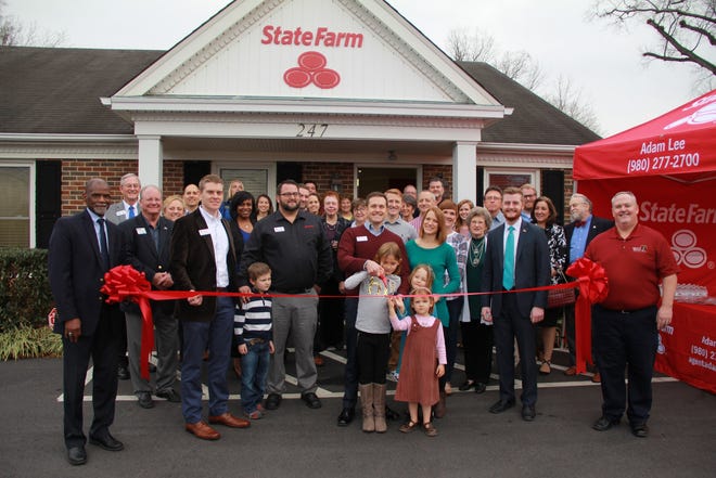 Adam Lee, his wife, Kristi, and their daughters, Aubrey, Makenna and Brooke, cut the ribbon in front of their new business. Also on the front row are agency team members (from left) Robert Nichols, Tony Merida and Davis Crawford. Holding the ribbon are Mount Holly Mayor Bryan Hough (right) and City Manager Danny Jackson. www.agentadamlee.com. [PHOTO COURTESY OF MONTCROSS AREA CHAMBER]
